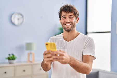 Photo for Young man smiling confident using smartphone at home - Royalty Free Image