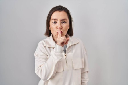 Photo for Middle age hispanic woman standing over isolated background asking to be quiet with finger on lips. silence and secret concept. - Royalty Free Image