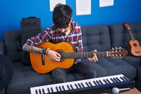 Photo for Young hispanic man artist playing classical guitar at music studio - Royalty Free Image