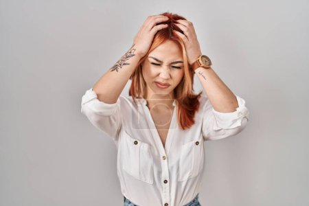 Photo for Young caucasian woman standing over isolated background suffering from headache desperate and stressed because pain and migraine. hands on head. - Royalty Free Image