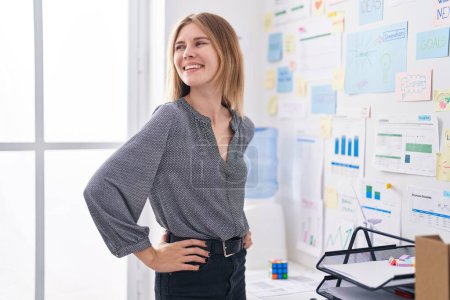 Photo for Young blonde woman business worker smiling confident standing at office - Royalty Free Image