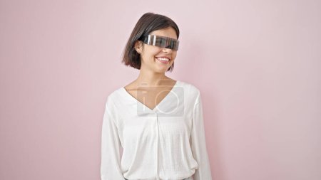 Photo for Young beautiful hispanic woman using virtual reality smiling over isolated pink background - Royalty Free Image