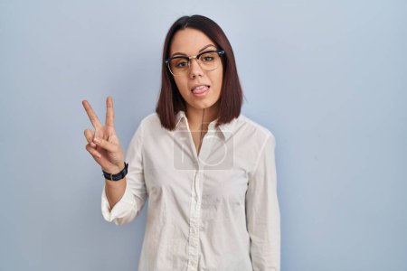 Téléchargez les photos : Young hispanic woman standing over white background showing and pointing up with fingers number two while smiling confident and happy. - en image libre de droit