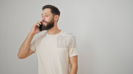 Téléchargez les photos : Jeune homme hispanique parlant sur le smartphone sur fond blanc isolé - en image libre de droit