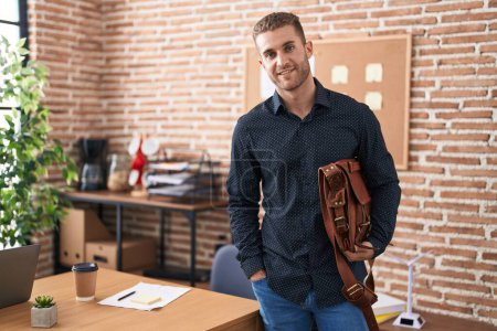 Téléchargez les photos : Young caucasian man business worker smiling confident holding briefcase at office - en image libre de droit