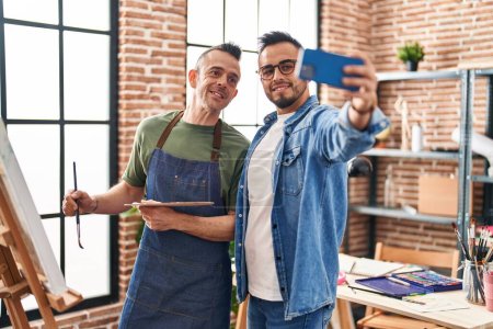 Téléchargez les photos : Two men artists smiling confident make selfie by smartphone at art studio - en image libre de droit