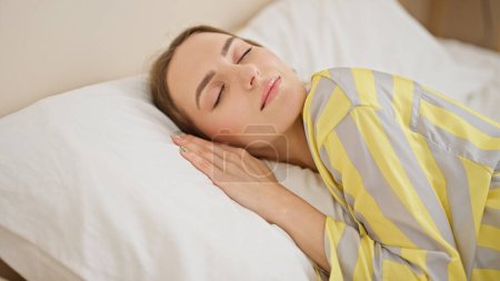 Téléchargez les photos : Jeune femme blonde couchée sur le lit dormant dans la chambre - en image libre de droit