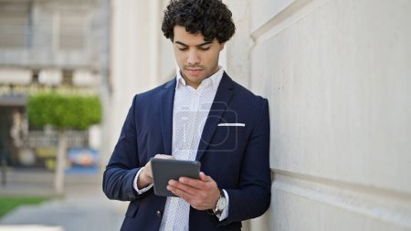 Photo for Young latin man business worker using touchpad at street - Royalty Free Image