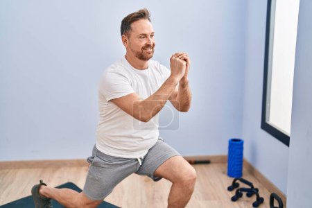 Photo for Young caucasian man smiling confident training leg exercise at sport center - Royalty Free Image