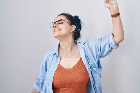 Photo for Young modern girl with blue hair standing over white background dancing happy and cheerful, smiling moving casual and confident listening to music - Royalty Free Image