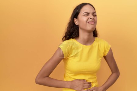Téléchargez les photos : Jeune femme afro-américaine souffrant de maux d'estomac debout sur fond jaune isolé - en image libre de droit