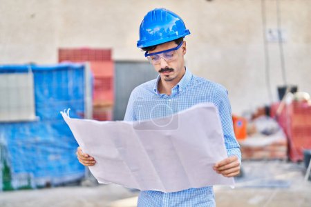 Photo for Young caucasian man architect looking house plans at street - Royalty Free Image