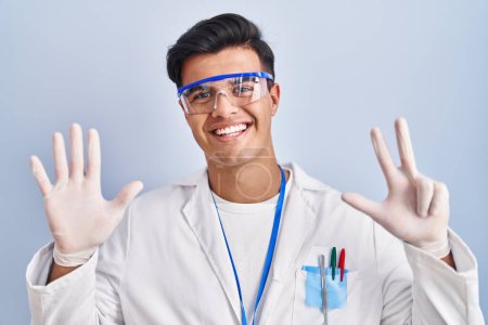 Photo for Hispanic man working as scientist showing and pointing up with fingers number eight while smiling confident and happy. - Royalty Free Image