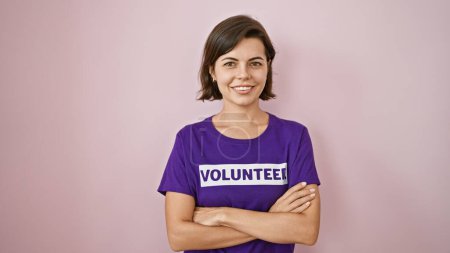 Téléchargez les photos : Jeune femme hispanique, volontaire, avec un sourire confiant et les bras croisés, debout fièrement sur un fond rose isolé - en image libre de droit