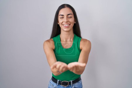 Photo for Young woman standing over isolated background smiling with hands palms together receiving or giving gesture. hold and protection - Royalty Free Image