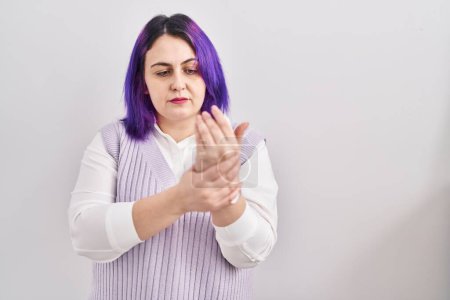 Téléchargez les photos : Plus taille femme esprit cheveux violets debout sur fond blanc souffrant de douleur sur les mains et les doigts, inflammation de l'arthrite - en image libre de droit