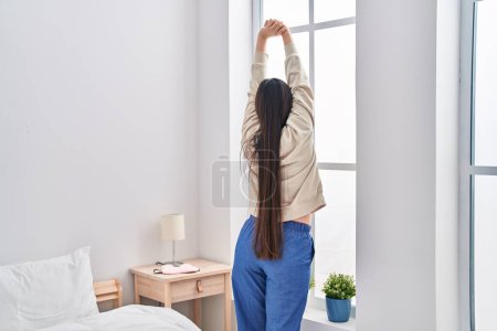Photo for Chinese woman waking up stretching arms at bedroom - Royalty Free Image