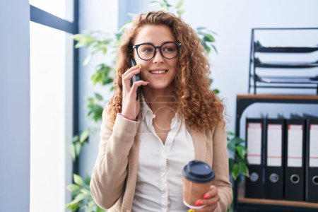 Téléchargez les photos : Young beautiful hispanic woman business worker talking on smartphone drinking coffee at office - en image libre de droit