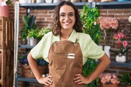 Photo for Young beautiful hispanic woman florist smiling confident standing at flower shop - Royalty Free Image