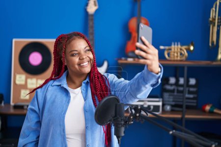 Foto de Mujer afroamericana artista hacer selfie por teléfono inteligente en el estudio de música - Imagen libre de derechos