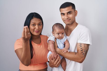 Photo for Young hispanic couple with baby standing together over isolated background doing italian gesture with hand and fingers confident expression - Royalty Free Image