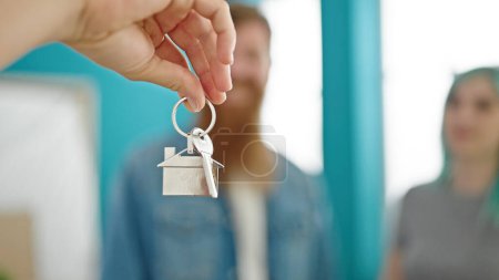 Photo for Man and woman couple receiving keys of real state agent at new home - Royalty Free Image