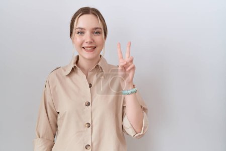 Téléchargez les photos : Jeune femme caucasienne portant chemise décontractée montrant et pointant vers le haut avec les doigts numéro deux tout en souriant confiant et heureux. - en image libre de droit