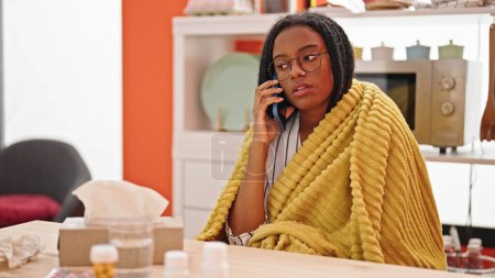 Photo for African american woman having medical consultation by smartphone being sick at dinning room - Royalty Free Image