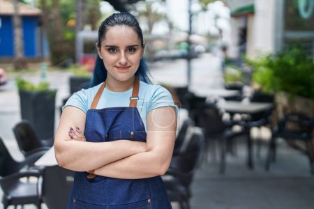 Foto de Young caucasian woman waitress smiling confident standing with arms crossed gesture at coffee shop terrace - Imagen libre de derechos