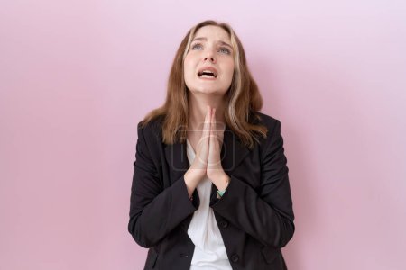 Photo for Young caucasian business woman wearing black jacket begging and praying with hands together with hope expression on face very emotional and worried. begging. - Royalty Free Image