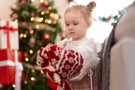 Photo for Adorable caucasian girl holding christmas sock standing at home - Royalty Free Image