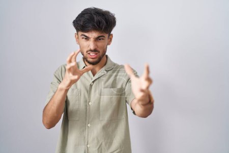Téléchargez les photos : Homme arabe avec la barbe debout sur fond blanc criant frustré par la rage, mains essayant d'étrangler, hurlant fou - en image libre de droit