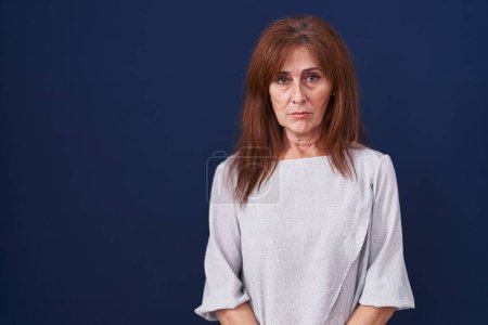 Photo for Middle age woman standing over blue background depressed and worry for distress, crying angry and afraid. sad expression. - Royalty Free Image
