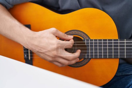 Photo for Young caucasian man playing classical guitar at home - Royalty Free Image