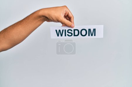 Téléchargez les photos : Main d'homme caucasien tenant du papier avec mot de sagesse sur fond blanc isolé - en image libre de droit