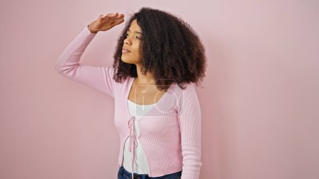 Foto de Mujer afroamericana buscando sobre fondo rosa aislado - Imagen libre de derechos