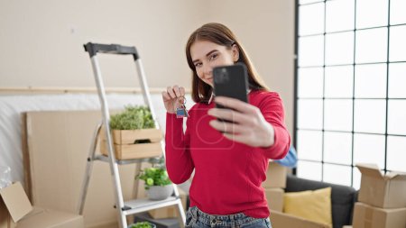 Foto de Mujer hispana joven hacer selfie por teléfono inteligente con llave de la casa en el nuevo hogar - Imagen libre de derechos