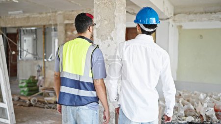 Photo for Two men builder and architect standing together backwards at construction site - Royalty Free Image