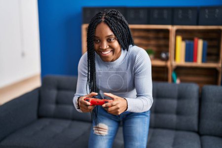 Photo for African american woman playing video game standing at home - Royalty Free Image