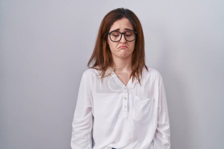 Photo for Brunette woman standing over white isolated background depressed and worry for distress, crying angry and afraid. sad expression. - Royalty Free Image