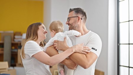 Téléchargez les photos : Famille de la mère, le père et le bébé souriant ensemble à la nouvelle maison - en image libre de droit