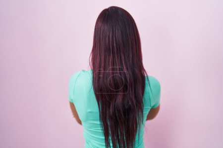Photo for Young hispanic woman standing over pink background standing backwards looking away with crossed arms - Royalty Free Image