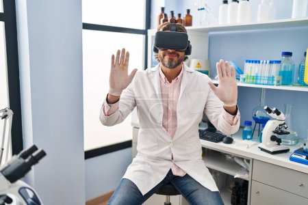 Téléchargez les photos : Homme scientifique du Moyen Âge utilisant des lunettes de réalité virtuelle au laboratoire - en image libre de droit
