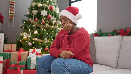 Photo for African american woman celebrating christmas with sad expression at home - Royalty Free Image