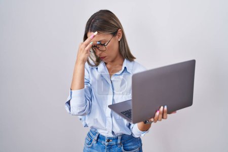 Foto de Mujer joven que trabaja usando computadora portátil cansado frotando la nariz y los ojos sintiendo fatiga y dolor de cabeza. concepto de estrés y frustración. - Imagen libre de derechos