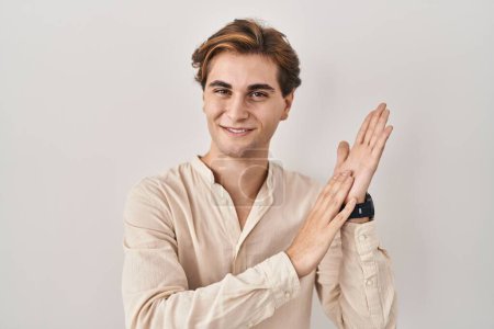 Téléchargez les photos : Young man standing over isolated background clapping and applauding happy and joyful, smiling proud hands together - en image libre de droit