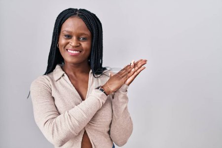 Téléchargez les photos : Femme africaine avec des tresses debout sur fond blanc applaudissements et applaudissements heureux et joyeux, souriant mains fières ensemble - en image libre de droit