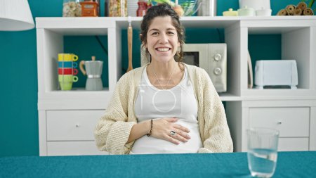 Photo for Young pregnant woman smiling confident speaking at dinning room - Royalty Free Image