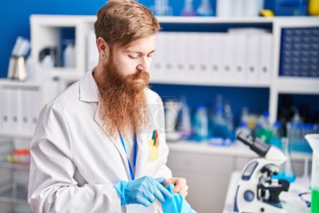 Photo for Young redhead man scientist wearing gloves at laboratory - Royalty Free Image