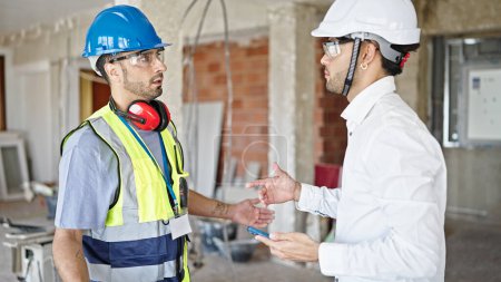 Photo for Two men builder and architect standing together speaking at construction site - Royalty Free Image